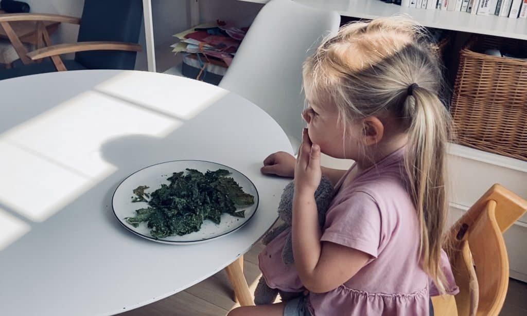 Vegan child eating kale chips